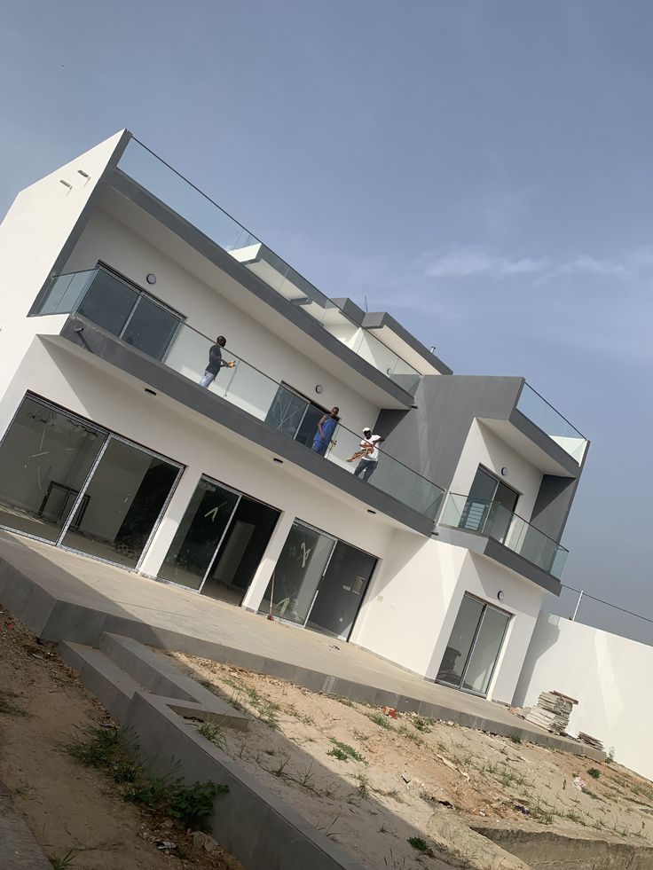 Modern two-storey villa under finishing works with glass balcony railings